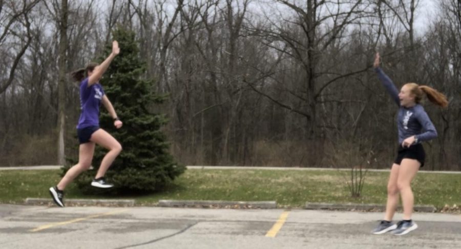 Emily Chizek(‘20) gives Riley Thorburn(‘21) a social distance high five after a long run they completed together while staying 6 feet apart.