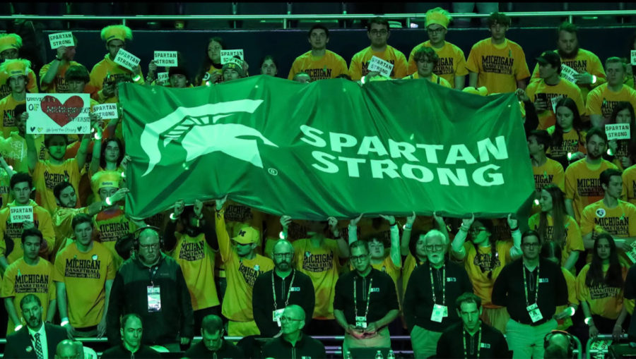 The Michigan student section holds up a Spartan Strong banner during game against the Spartans in honor of those who were affected by the shooting.  (photo credit: freepress.com)