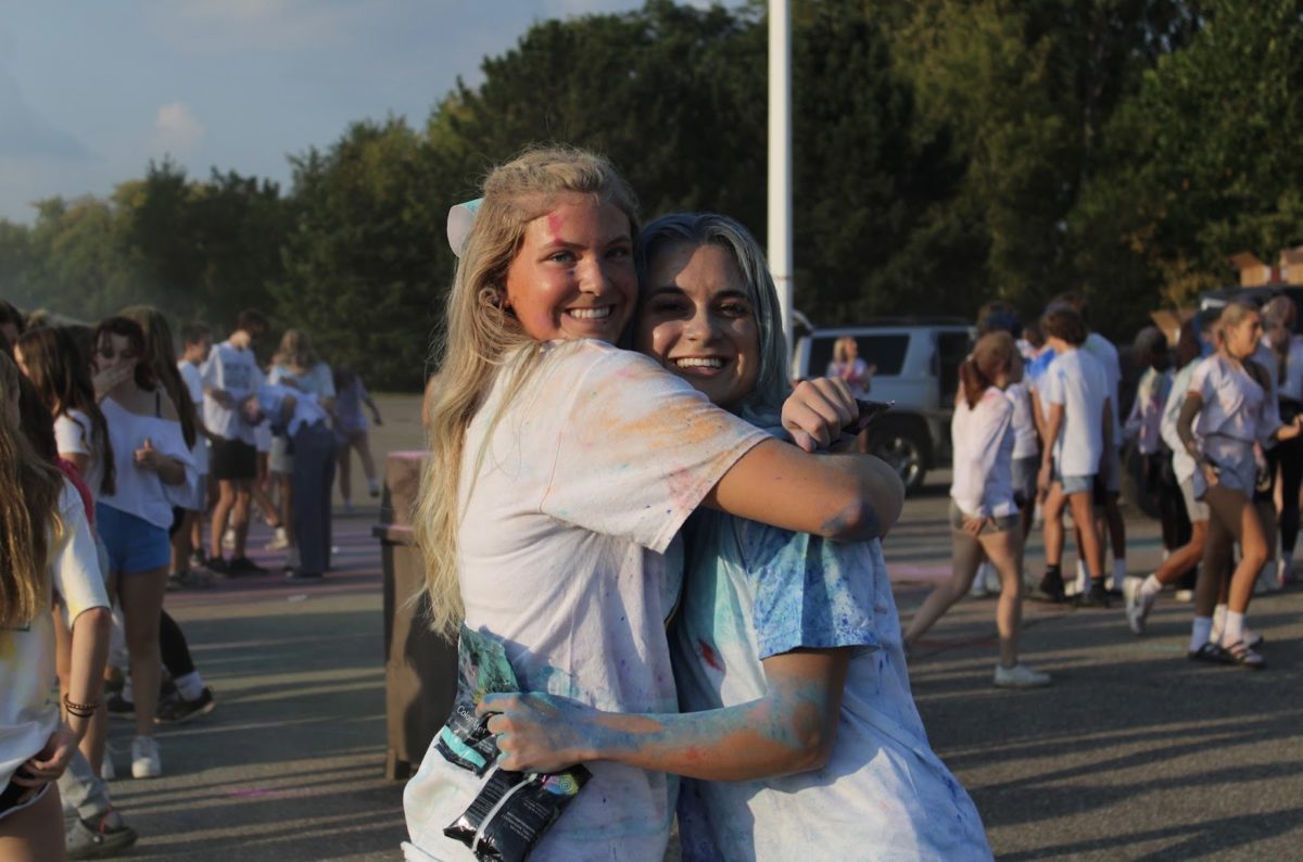 From left to right: Senior Katelyn Naebeck stops for a quick hug with fellow senior Carley Grabarczyk  before rushing off to cheer for the CHS football team.