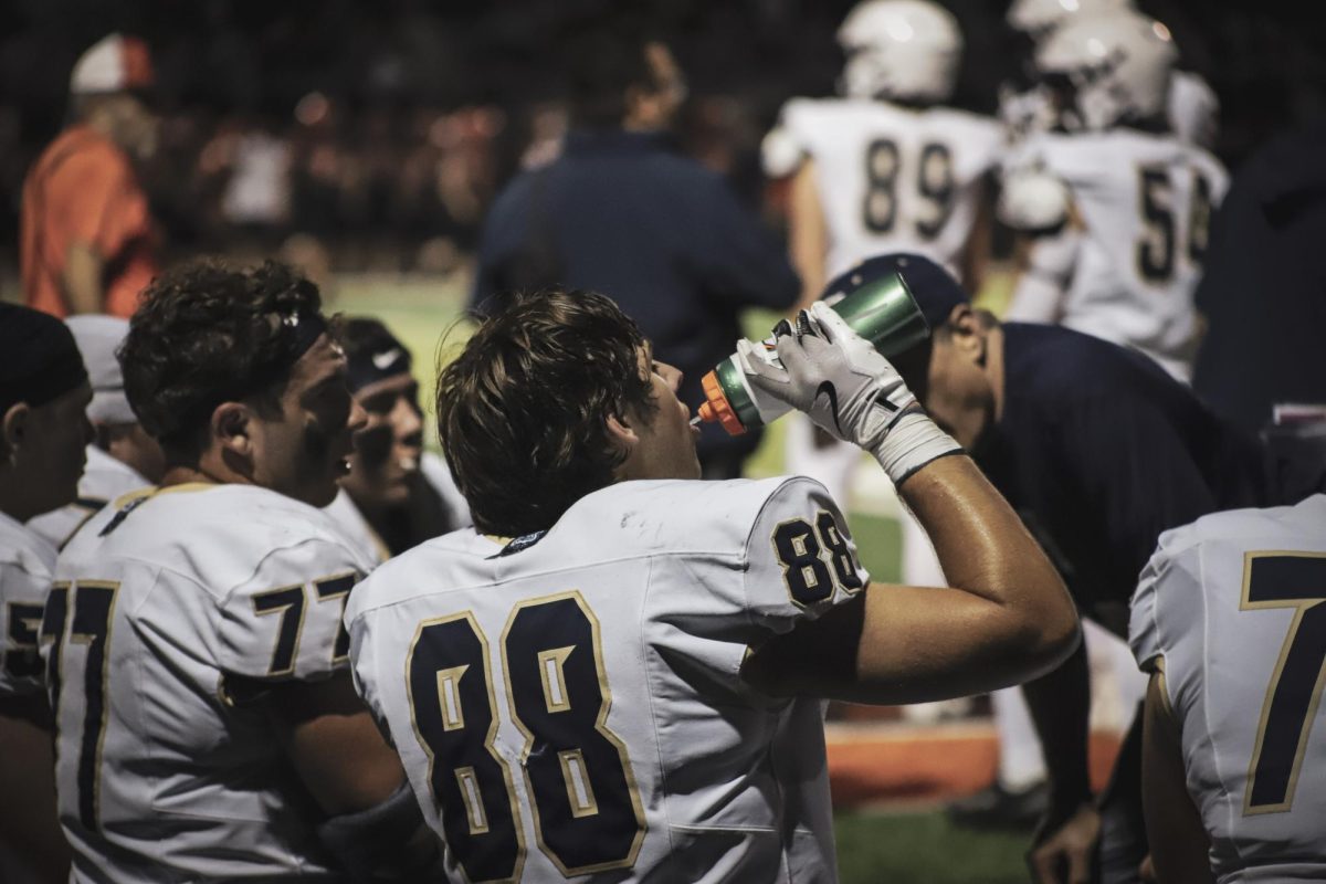 Sophomore Josh Stevens hydrating after an intense play 